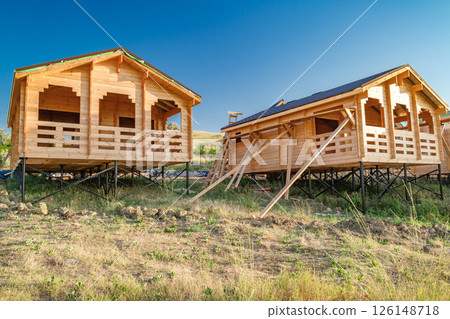 wooden guest houses being built on hillside 126148718