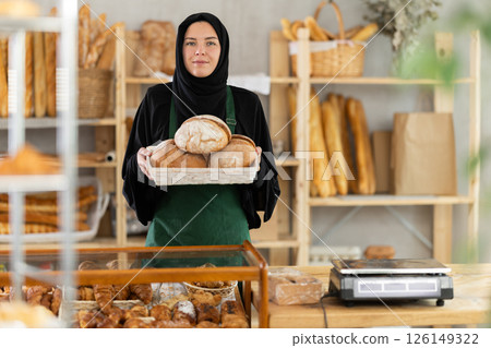 European Muslim woman bakery worker sells bread, stand at counter and wait for visitors 126149322