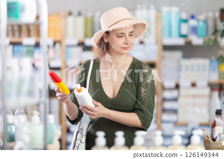 Woman buyer select sunscreen cream 126149344
