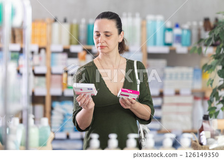 Woman are busy choosing paracetamol tablet box at pharmacy Woman are busy choosing paracetamol tablet box at pharmacy 126149350