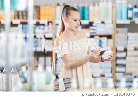 Woman in a summer dress chooses pills for toxicosis 126149370
