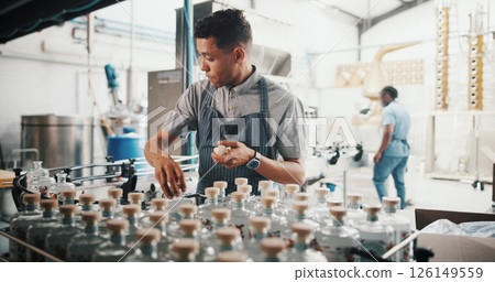 Distillery, worker and sealing bottle in factory for alcohol production process, packaging and spirits storage. Assembly line, man and cork drink by machine for beverage supply and quality control 126149559