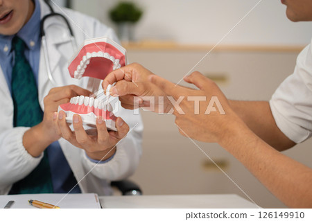 Dentist working tooth model, dentistry and recommend patient concept. Dentist working tooth model, dentistry and recommend patient concept. 126149910