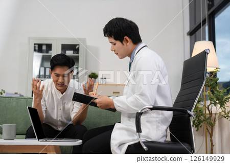 Concerned male patient, patient talks with healthcare professional and signing medical paper at appointment visit in clinic. Concerned male patient, patient talks with healthcare professional and signing medical paper at appointment visit in clinic. 126149929