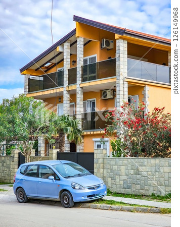 Orange Two-Story House with Blue Car Parked Outside 126149968