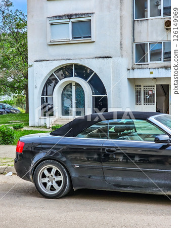 Curved Window of Residential House with Black Car Partial View 126149969