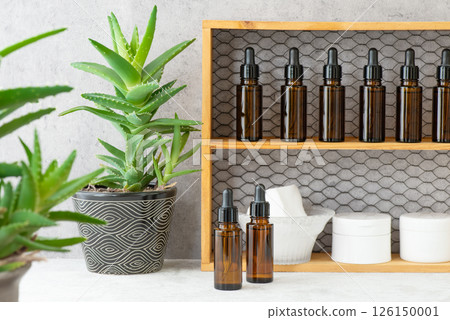 架子上擺滿了棕色遮光瓶和一盆蘆薈 126150001