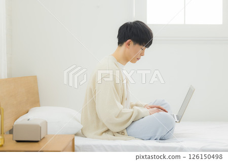 男人在床上使用筆記型電腦 126150498