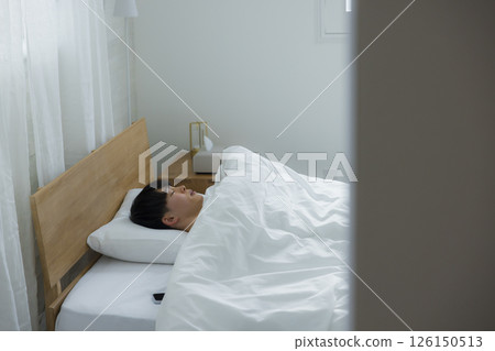 A man who uses smartphones in bed A man who uses smartphones in bed 126150513