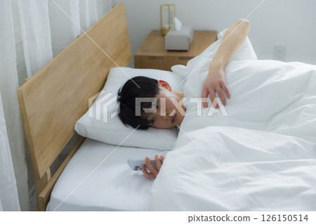 A man who uses smartphones in bed 126150514