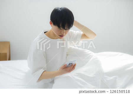 A man who uses smartphones in bed 126150518