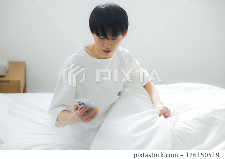 A man who uses smartphones in bed 126150519