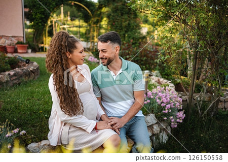 Couple shares tender moments in serene garden setting 126150558