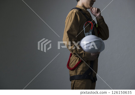Male worker wearing a full harness 126150635