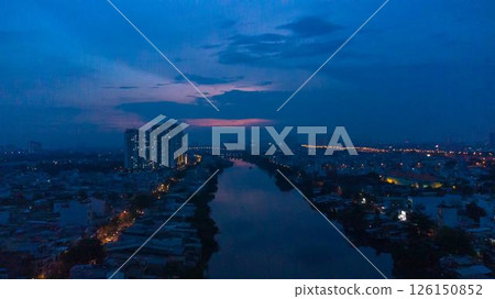 Aerial view of illuminated church by river surrounded by high rise residential buildings and city streets during blue hour with urban skyline and canal cityscape at twilight. High quality photo Aerial view of illuminated church by river surrounded by high rise residential buildings and city streets during blue hour with urban skyline and canal cityscape at twilight. High quality photo 126150852