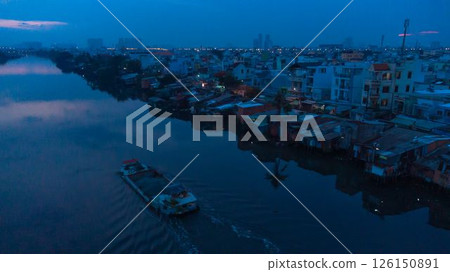 Aerial view of illuminated church by river surrounded by high rise residential buildings and city streets during blue hour with urban skyline and canal cityscape at twilight. High quality photo Aerial view of illuminated church by river surrounded by high rise residential buildings and city streets during blue hour with urban skyline and canal cityscape at twilight. High quality photo 126150891