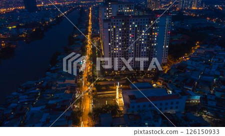 Aerial view of illuminated church by river surrounded by high rise residential buildings and city streets during blue hour with urban skyline and canal cityscape at twilight. High quality photo Aerial view of illuminated church by river surrounded by high rise residential buildings and city streets during blue hour with urban skyline and canal cityscape at twilight. High quality photo 126150933