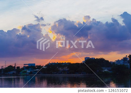 Towering cumulus clouds glowing in golden sunlight against clear blue sky at sunset with dramatic natural cloudscape and atmospheric light. High quality photo Towering cumulus clouds glowing in golden sunlight against clear blue sky at sunset with dramatic natural cloudscape and atmospheric light. High quality photo 126151072
