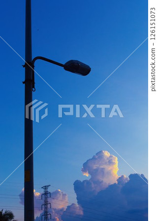 Towering cumulus clouds glowing in golden sunlight against clear blue sky at sunset with dramatic natural cloudscape and atmospheric light. High quality photo Towering cumulus clouds glowing in golden sunlight against clear blue sky at sunset with dramatic natural cloudscape and atmospheric light. High quality photo 126151073
