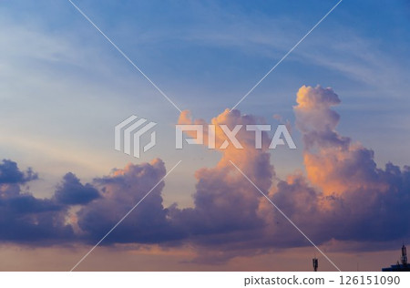 Towering cumulus clouds glowing in golden sunlight against clear blue sky at sunset with dramatic natural cloudscape and atmospheric light. High quality photo Towering cumulus clouds glowing in golden sunlight against clear blue sky at sunset with dramatic natural cloudscape and atmospheric light. High quality photo 126151090