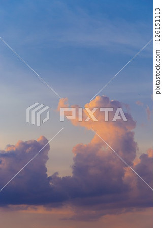 Towering cumulus clouds glowing in golden sunlight against clear blue sky at sunset with dramatic natural cloudscape and atmospheric light. High quality photo Towering cumulus clouds glowing in golden sunlight against clear blue sky at sunset with dramatic natural cloudscape and atmospheric light. High quality photo 126151113