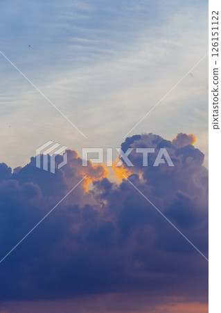 Towering cumulus clouds glowing in golden sunlight against clear blue sky at sunset with dramatic natural cloudscape and atmospheric light. High quality photo Towering cumulus clouds glowing in golden sunlight against clear blue sky at sunset with dramatic natural cloudscape and atmospheric light. High quality photo 126151122