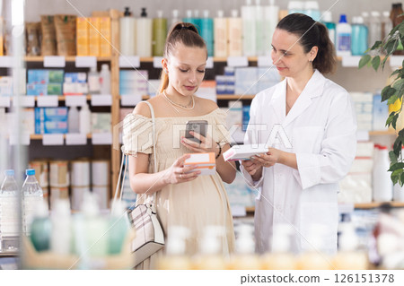 Pregnant woman buyer scans pills qr code with woman pharmacist 126151378
