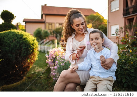 Mom and son share a joyful moment in the garden 126151616