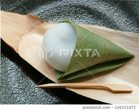 竹餅的照片，這是一種用竹葉包裹的懷舊美食，盛放在竹皮和黑色盤子裡 126151873