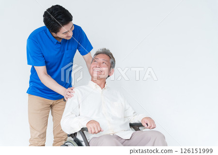 Male caregiver and elderly man in a wheelchair Male caregiver and elderly man in a wheelchair 126151999