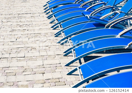close-up empty blue deck chairs stand in a row outdoors 126152414