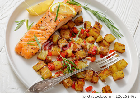 Oven-baked salmon fillet with fried potato, lemon 126152463