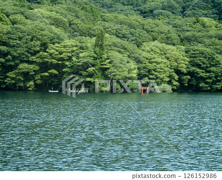 A view of a small torii gate and a mountain from the boat 126152986