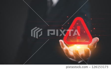 Businessman holding a digital warning triangle, representing cybersecurity threats, data protection scam sms spam alert link, and risk management caution fraud attention , cyber attack malware data. 126153173