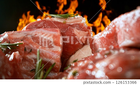 Large assortment of premium raw meat, beef, sausages, pork and chicken suitable for butchery advertising, fire on background 126153366