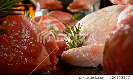 Large assortment of premium raw meat, beef, sausages, pork and chicken suitable for butchery advertising, fire on background 126153367