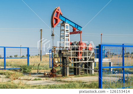 Oil pump in field on background of blue sky 126153414