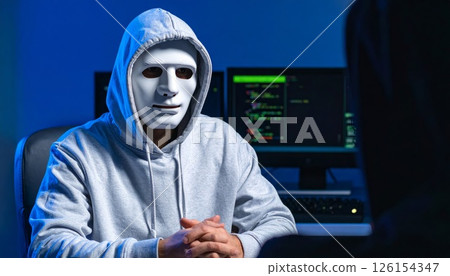 Hacker in a hood and mask is talking during interview, anonymous man, hidden identity concept 126154347
