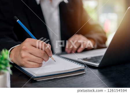man hands with pen writing on notebook in the office.learning, education and work.writes goals, plans, make to do and wish list on desk. man hands with pen writing on notebook in the office.learning, education and work.writes goals, plans, make to do and wish list on desk. 126154594
