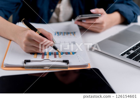 Business data review with hand marking graph on clipboard, financial reporting, marketing insight, budgeting and strategy development in corporate work. 126154601