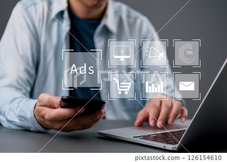 Digital marketing concept with man using laptop and smartphone, online advertising, social media campaign, analytics, e-commerce tools and customer targeting strategy. Digital marketing concept with man using laptop and smartphone, online advertising, social media campaign, analytics, e-commerce tools and customer targeting strategy. 126154610
