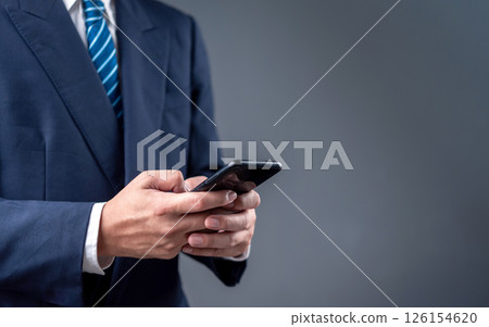 businessman using a smartphone for digital communication in a modern professional setting. The image reflects mobile technology and business connectivity. businessman using a smartphone for digital communication in a modern professional setting. The image reflects mobile technology and business connectivity. 126154620