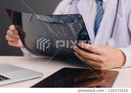 Doctor working with medical imaging and technology to provide accurate diagnosis. Ideal for hospitals, patient care, and healthcare professionals. doctor diagnosing brain problems using x-ray films. 126155010