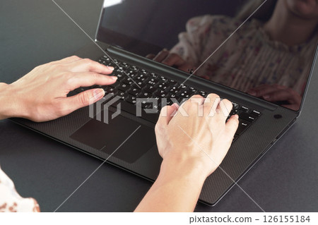 Young female working with laptop computer - detail on her hands over back keyboard Young female working with laptop computer - detail on her hands over back keyboard 126155184