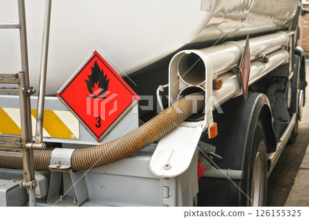 Red Warning hazmat Flammable class 3 liquid sign on back of fuel truck at petrol station 126155325