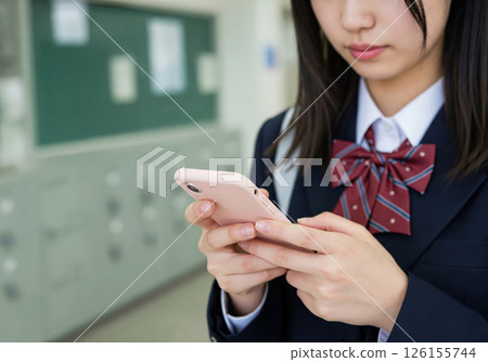 A female high school student using a smartphone in front of a classroom (AI-generated image) 126155744