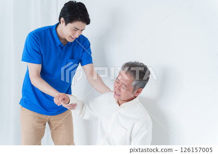 Elderly man with shoulder pain and staff Elderly man with shoulder pain and staff 126157005