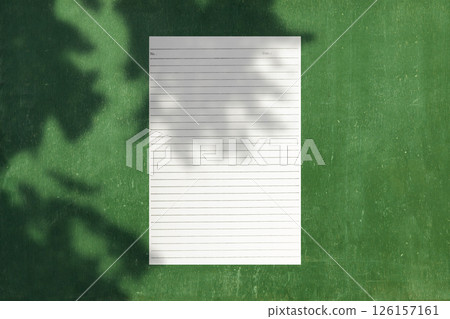 Top view of business letterhead with shadow on green background. Blank paper or sheet. Mockup or copy space for your design Top view of business letterhead with shadow on green background. Blank paper or sheet. Mockup or copy space for your design 126157161