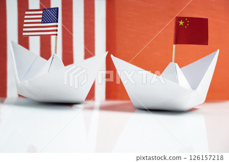 Paper boat with the USA or United States of America and China flags. Concept of the United States of America versus China trade war disputes or economic conflict Paper boat with the USA or United States of America and China flags. Concept of the United States of America versus China trade war disputes or economic conflict 126157218