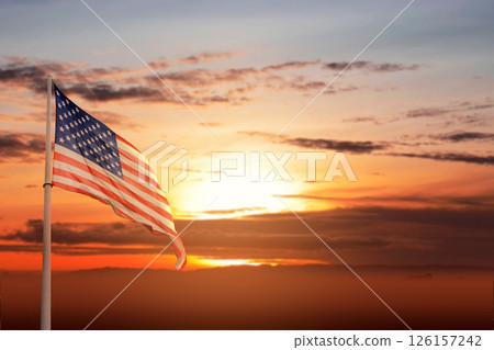 American flag on the pole, waving against a sunset scene background. Concept of Memorial Day, Remember and Honor American flag on the pole, waving against a sunset scene background. Concept of Memorial Day, Remember and Honor 126157242